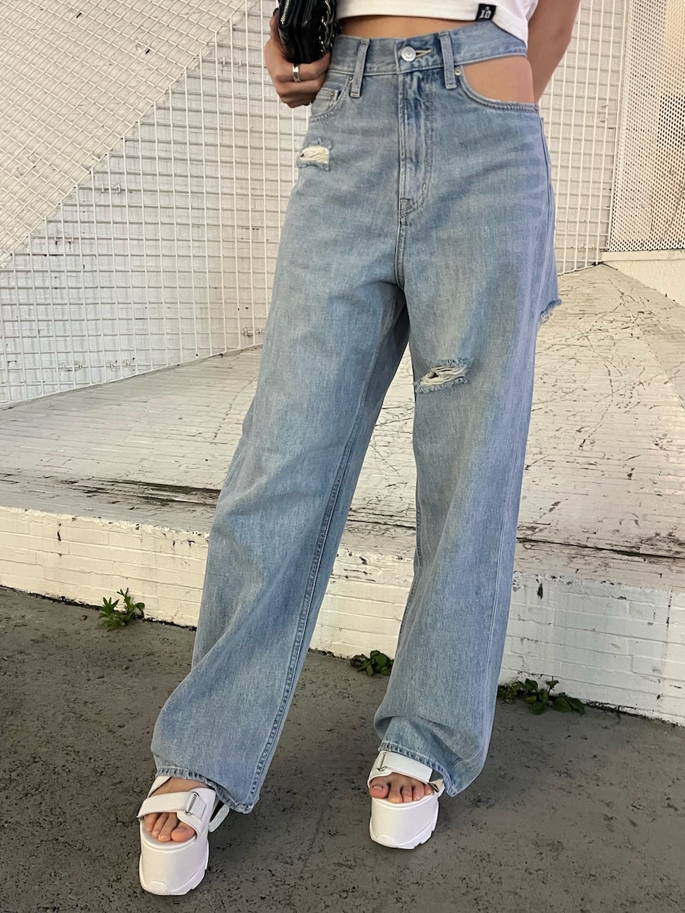 ブルー系のデニムパンツ、ホワイト系のTシャツ/カットソー、ブラック系のショルダーバッグを着用したレディースの夏コーディネートの6枚目の写真