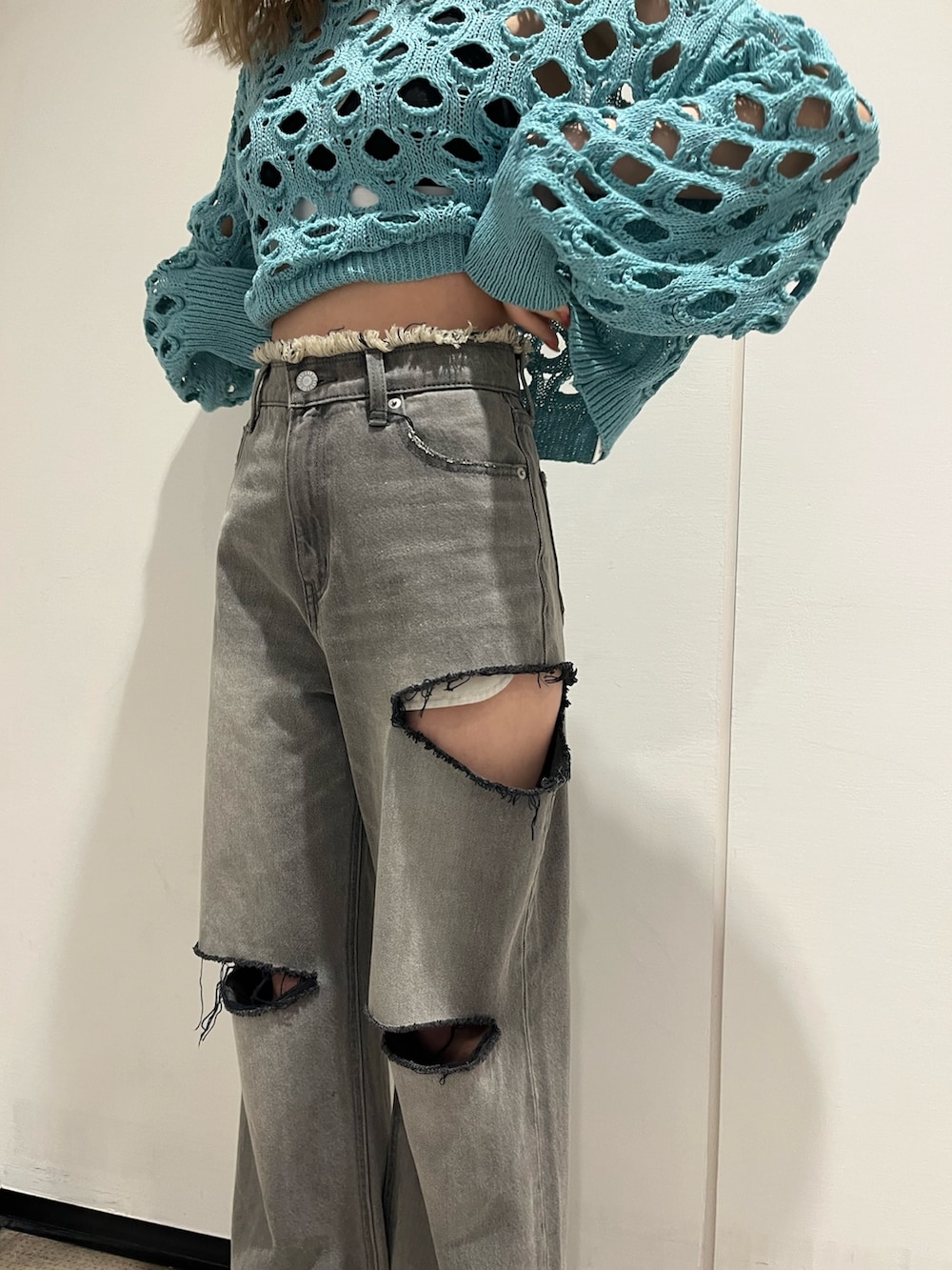 ブラック系のデニムパンツ、ブラック系のブーツ、ブルー系のニット/セーターを着用したレディースの冬コーディネートの6枚目の写真