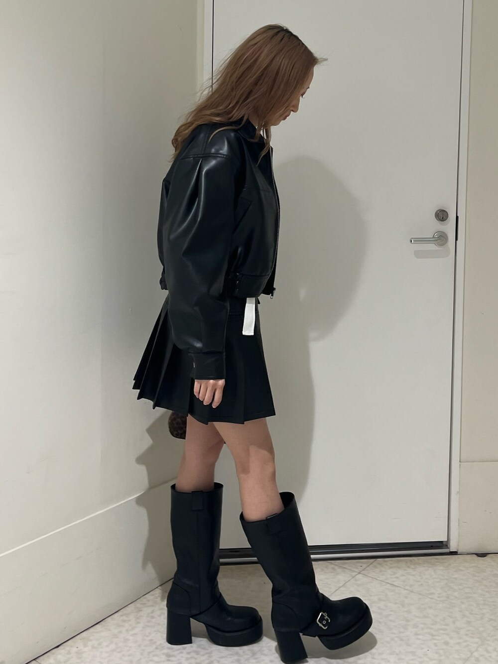 ブラウン系のブルゾン、ブラウン系のスカート、ブラウン系のハンドバッグを着用したレディースの春コーディネートの3枚目の写真