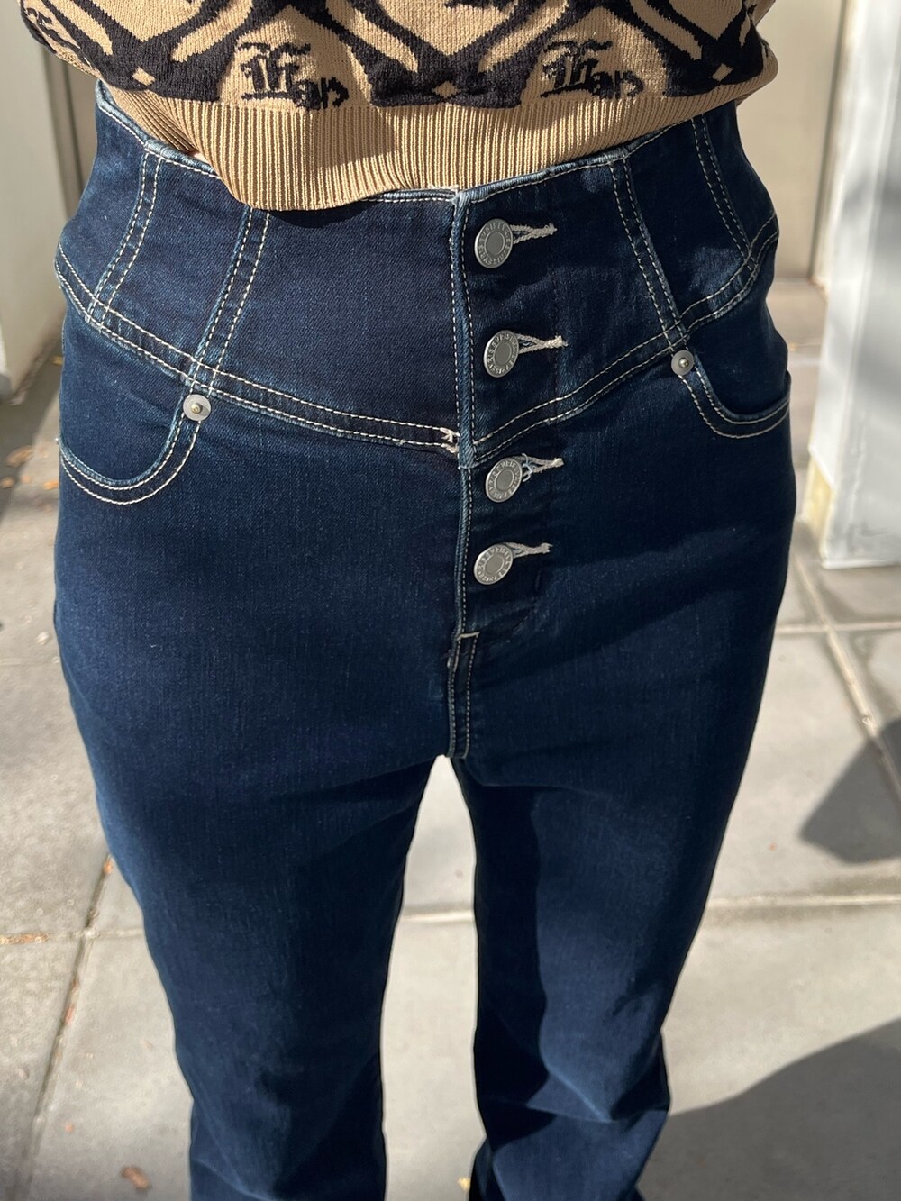 ブルー系のショルダーバッグ、ブルー系のデニムパンツ、ベージュ系のニット/セーターを着用したレディースの冬コーディネートの6枚目の写真