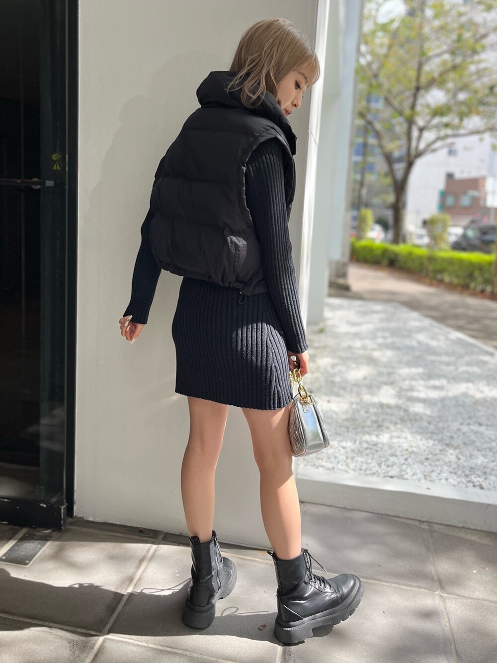 ホワイト系のブーツ、シルバー系のショルダーバッグ、ブラック系のワンピースを着用したレディースの秋コーディネートの4枚目の写真