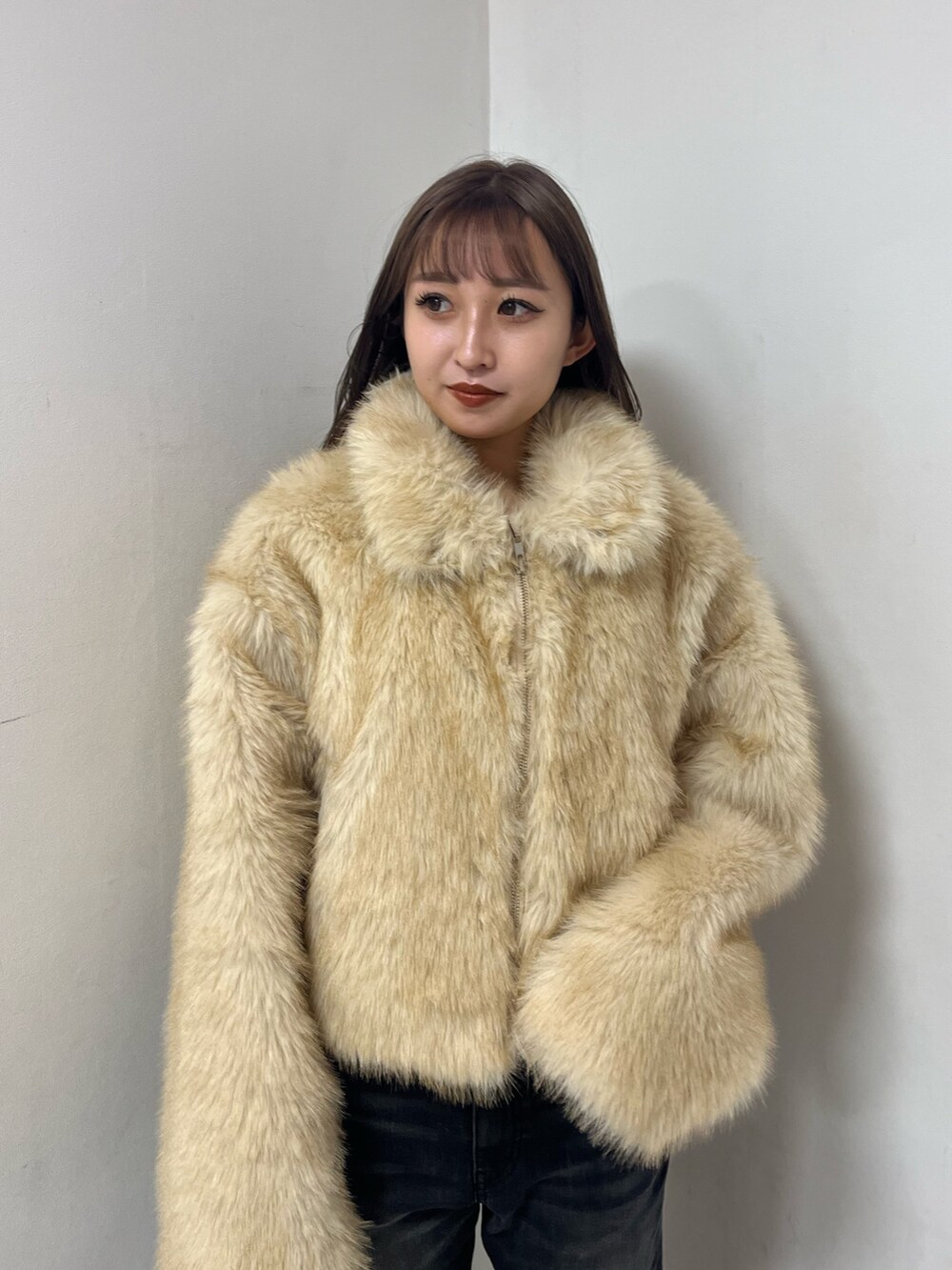 ベージュ系のブルゾン、ホワイト系のニット/セーター、ブラック系のデニムパンツを着用したレディースの冬コーディネートの5枚目の写真