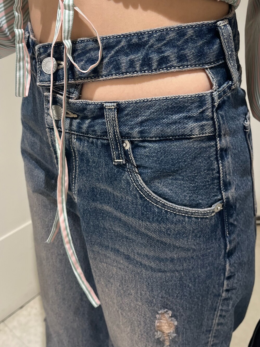 ブルー系のデニムパンツ、ピンク系のニット/セーター、ブラック系のボストンバッグを着用したレディースの春コーディネートの7枚目の写真