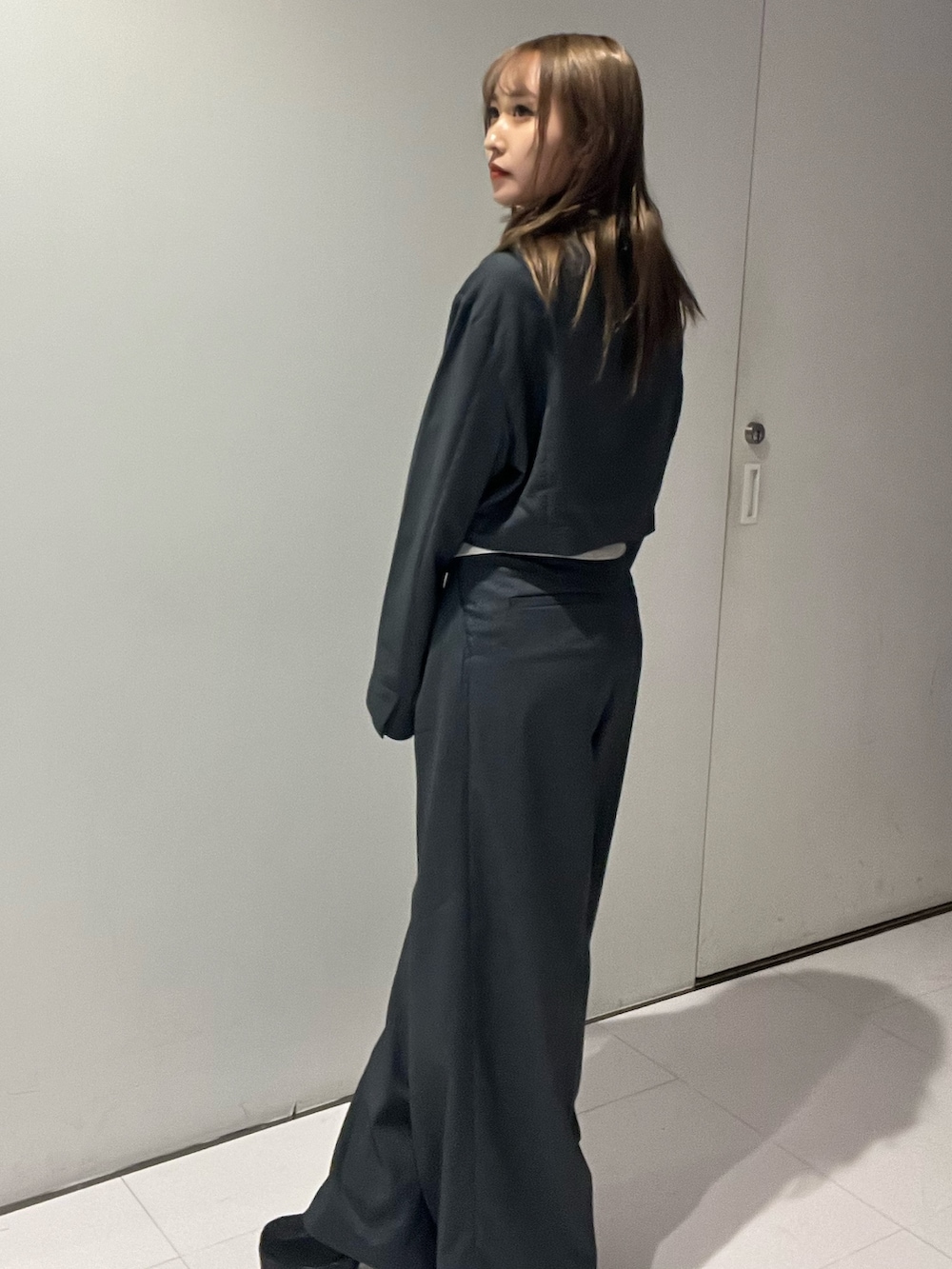 グレー系のテーラードジャケット、ブラック系のTシャツ/カットソー、グレー系のその他パンツを着用したレディースの秋コーディネートの2枚目の写真