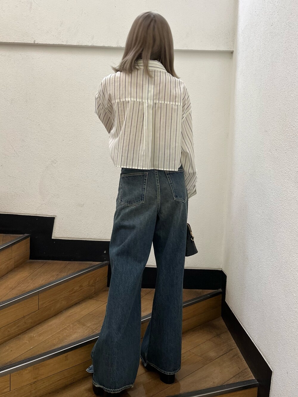 ブラック系のショルダーバッグ、ブラック系のブーツ、ホワイト系のシャツ/ブラウスを着用したレディースの冬コーディネートの3枚目の写真