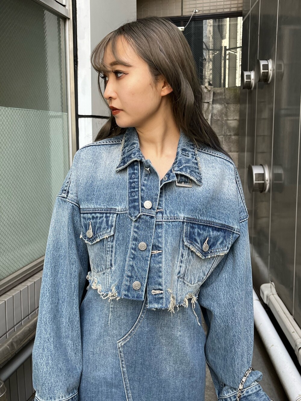 ブルー系のデニムジャケット、ブルー系のワンピース、ブルー系のショルダーバッグを着用したレディースの冬コーディネートの10枚目の写真