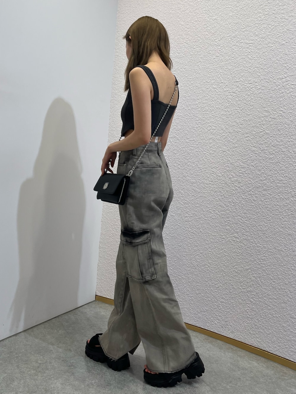 シルバー系のショルダーバッグ、ブラック系のキャミソール、ブラック系のデニムパンツを着用したレディースの夏コーディネートの2枚目の写真