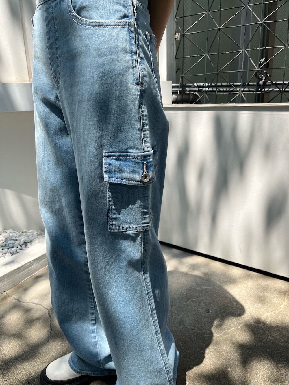 ブルー系のつなぎ/オールインワン、ホワイト系のブーツ、ブラック系のサングラスを着用したレディースの夏コーディネートの5枚目の写真