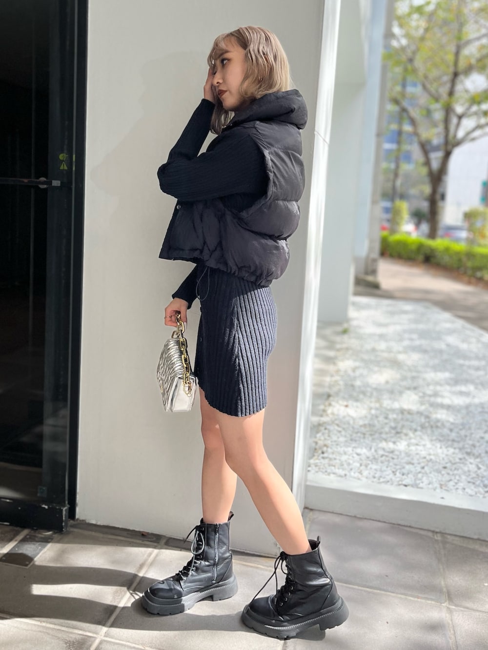 ホワイト系のブーツ、シルバー系のショルダーバッグ、ブラック系のワンピースを着用したレディースの秋コーディネートの3枚目の写真