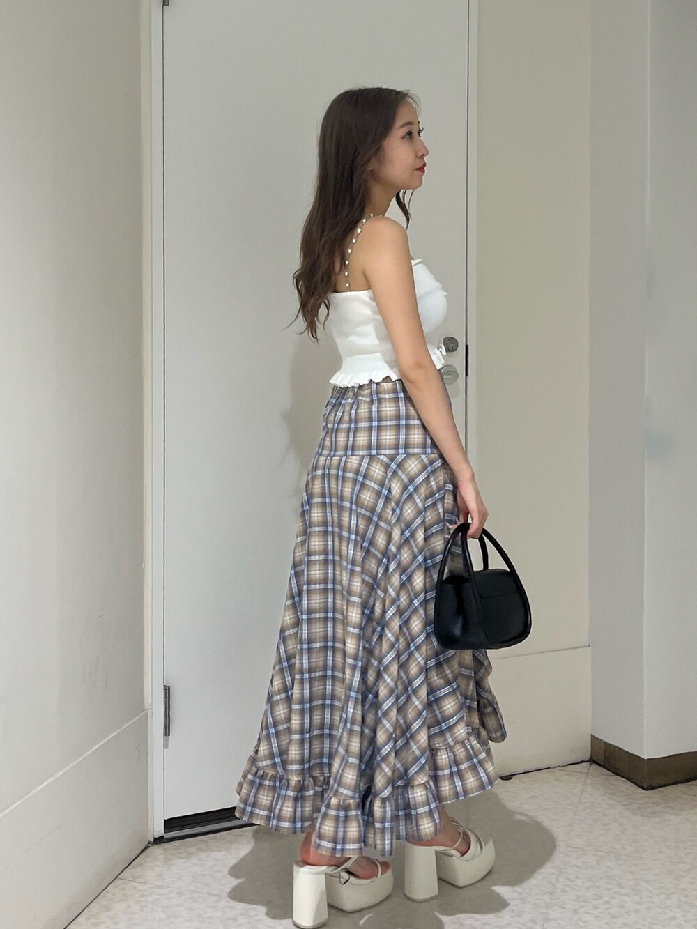 グレー系のスカート、レッド系のキャミソール、ブラック系のハンドバッグを着用したレディースの夏コーディネートの4枚目の写真