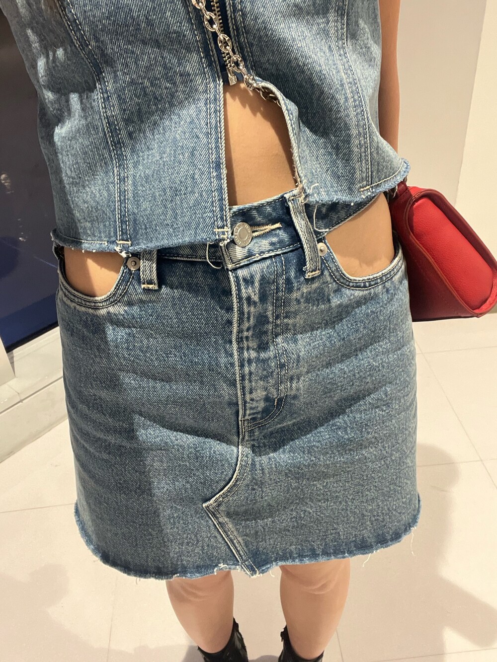 ブルー系のキャミソール、ブラック系のデニムスカート、シルバー系のブーツを着用したレディースの夏コーディネートの2枚目の写真