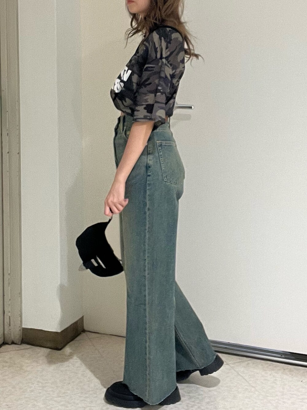 ブルー系のデニムパンツ、その他のTシャツ/カットソー、ブラック系のブーツを着用したレディースの春コーディネートの5枚目の写真