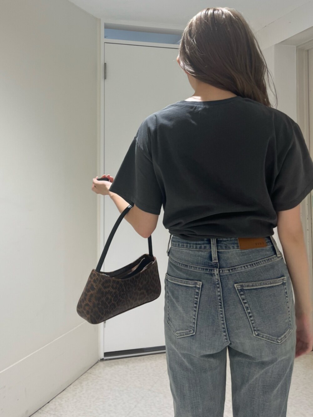 ブラウン系のハンドバッグ、ブラック系のサンダル、ブラック系のTシャツ/カットソーを着用したレディースの夏コーディネートの5枚目の写真