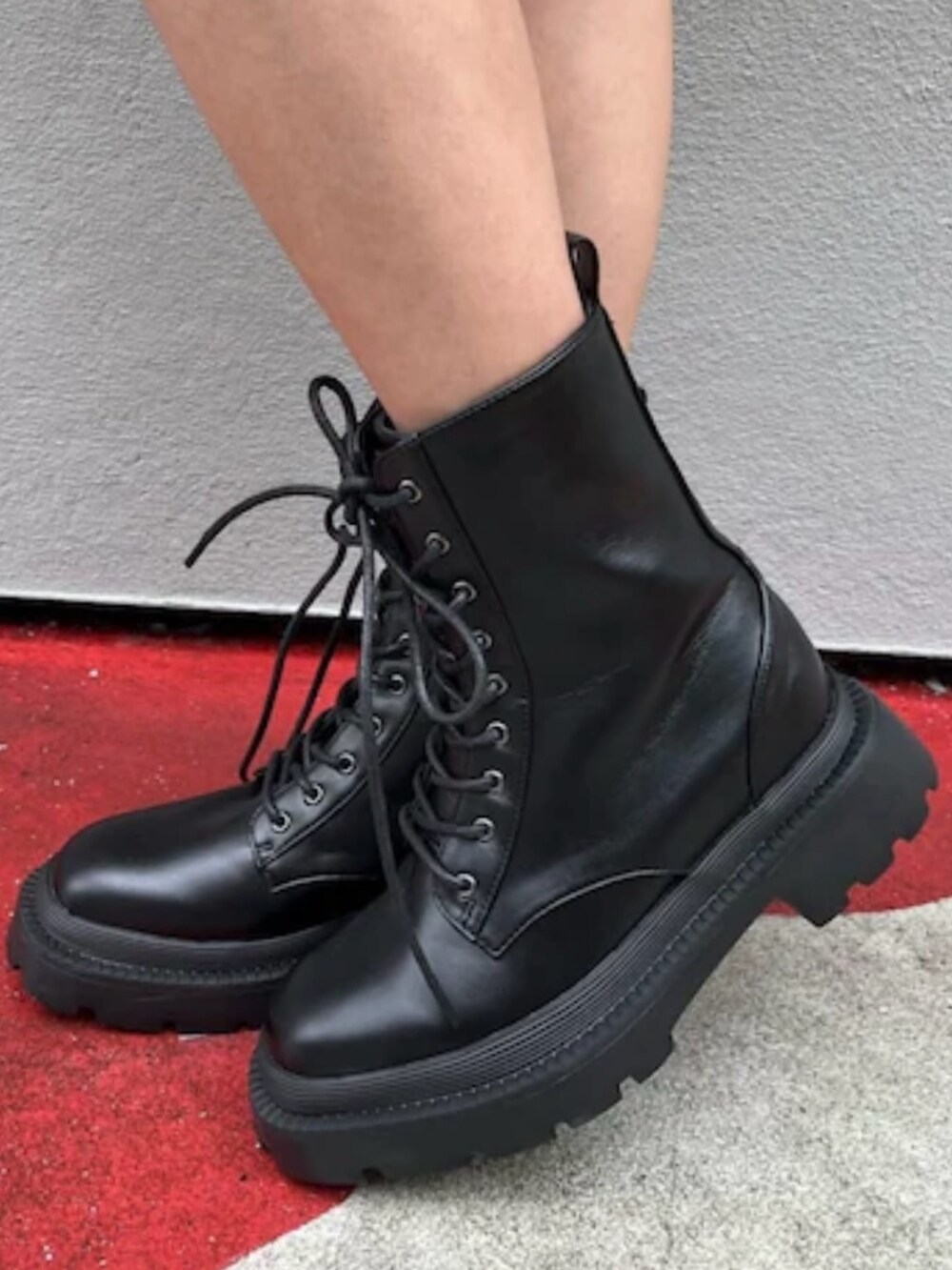 シルバー系のブーツ、グレー系のベスト、ホワイト系のスカートを着用したレディースの夏コーディネートの7枚目の写真