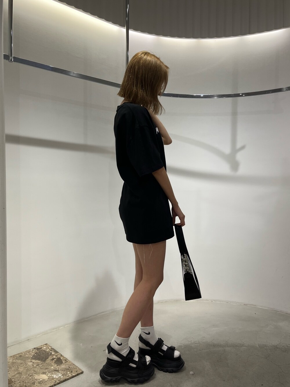 ブラック系のサンダル、ホワイト系のハンドバッグ、ホワイト系のTシャツ/カットソーを着用したレディースの夏コーディネートの4枚目の写真