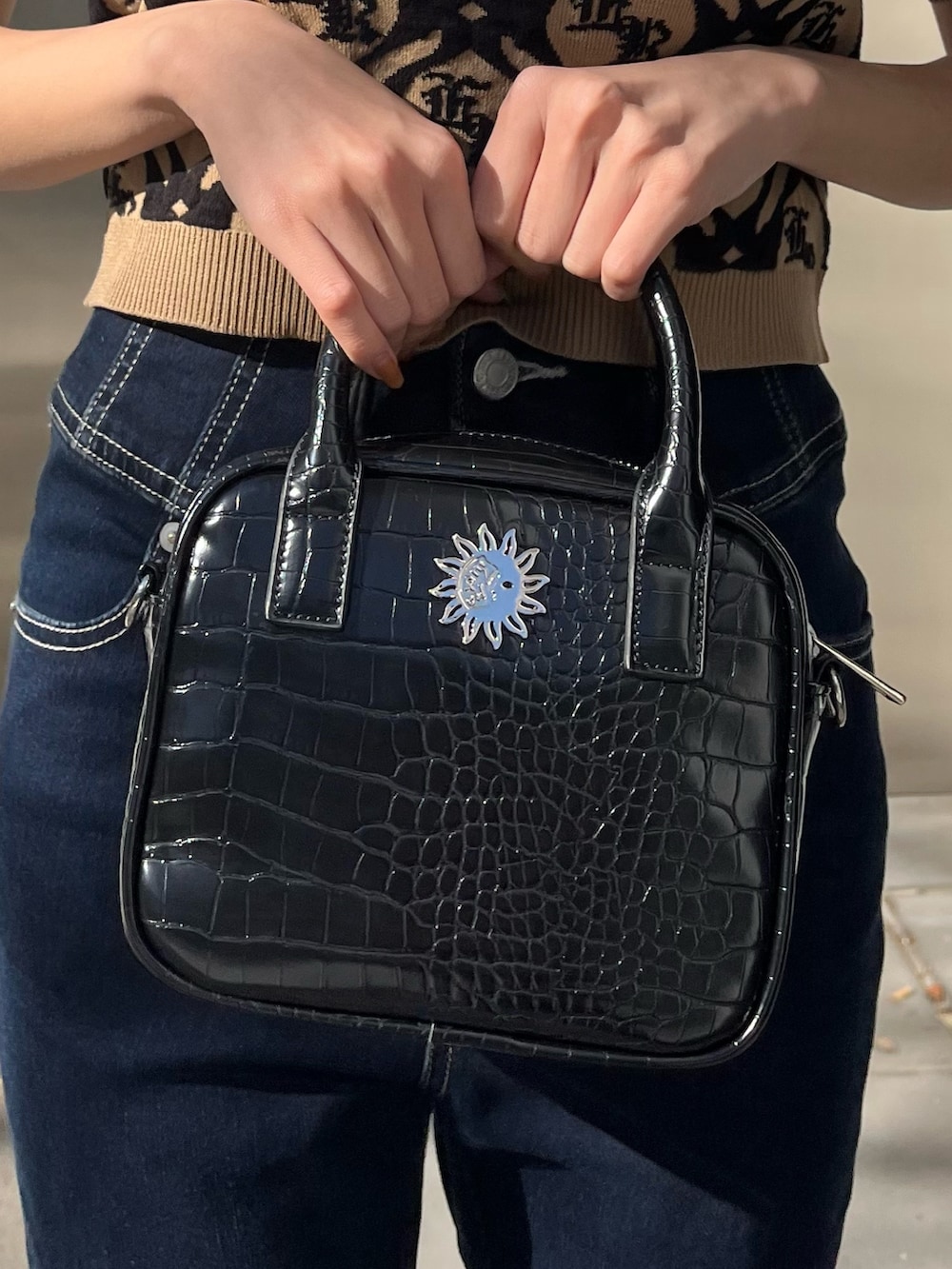 ブルー系のショルダーバッグ、ブルー系のデニムパンツ、ベージュ系のニット/セーターを着用したレディースの冬コーディネートの5枚目の写真