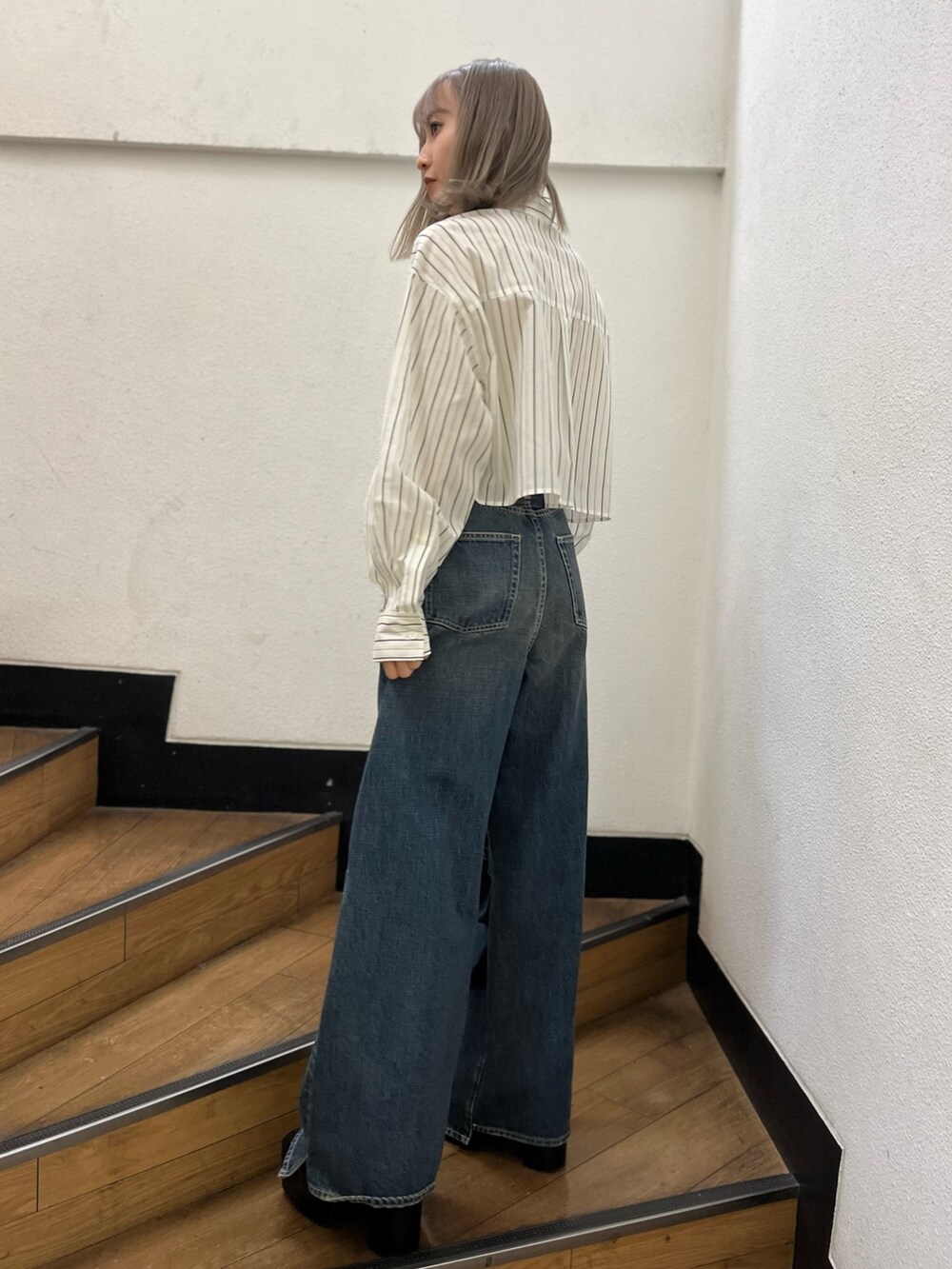 ブラック系のショルダーバッグ、ブラック系のブーツ、ホワイト系のシャツ/ブラウスを着用したレディースの冬コーディネートの2枚目の写真