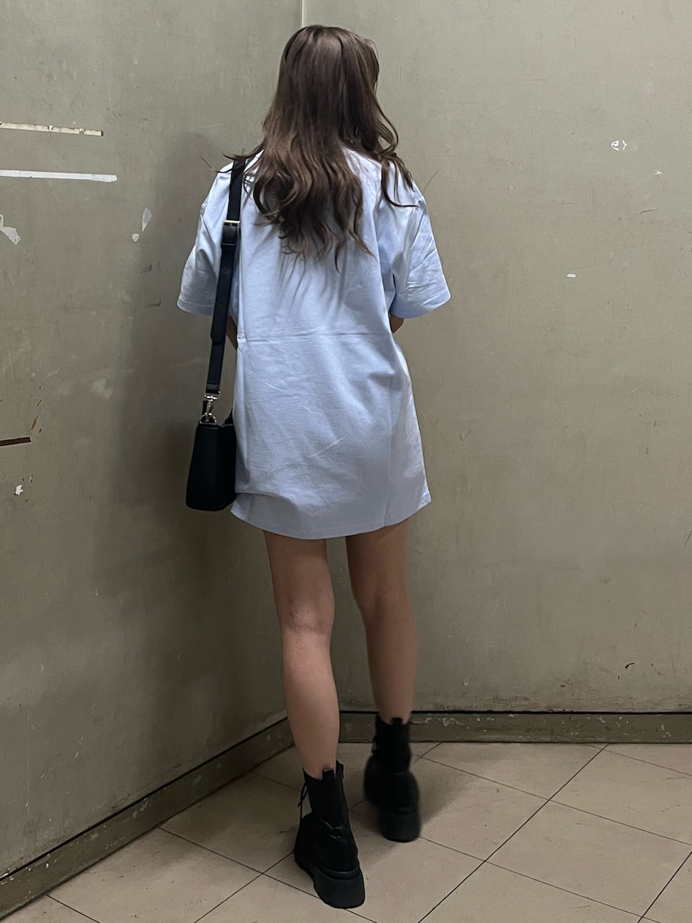 ブラック系のショルダーバッグ、ブラック系のブーツ、ブルー系のTシャツ/カットソーを着用したレディースの春コーディネートの3枚目の写真