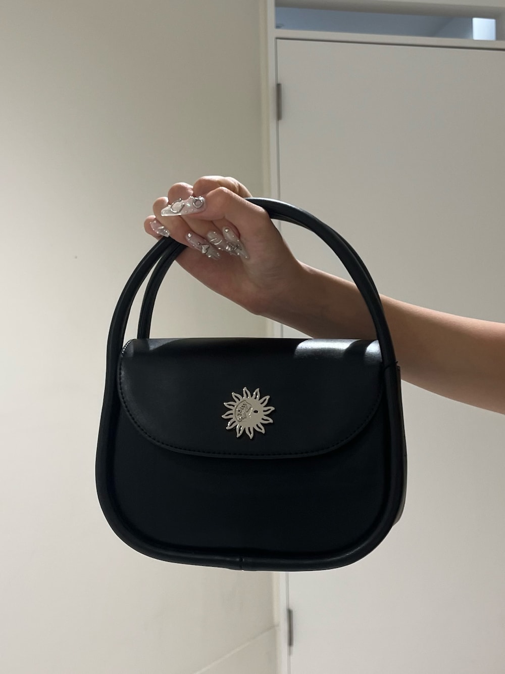 ブラック系のTシャツ/カットソー、ベージュ系のスカート、ブラック系のハンドバッグを着用したレディースの夏コーディネートの6枚目の写真