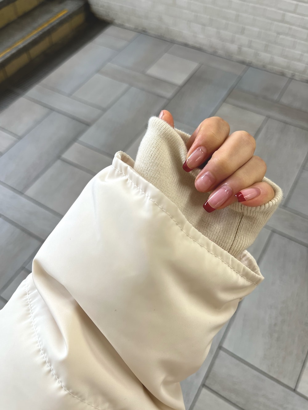 ブラック系のブーツ、ホワイト系のダウンジャケット/コート、ブラック系のショルダーバッグを着用したレディースの冬コーディネートの5枚目の写真