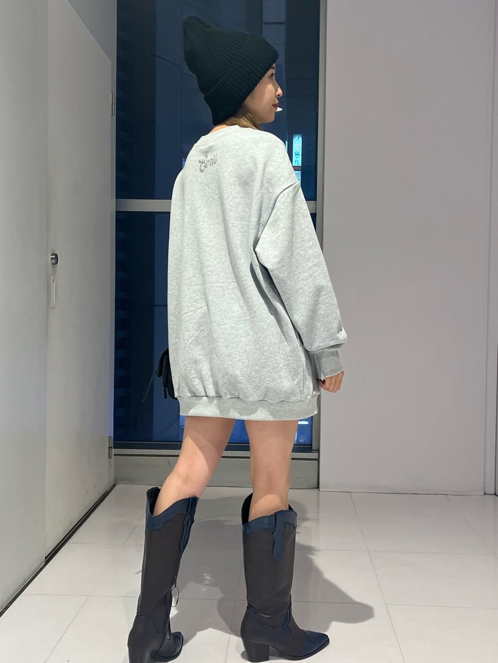 ブラック系のハンドバッグ、グレー系のTシャツ/カットソー、ブラウン系のブーツを着用したレディースの秋コーディネートの4枚目の写真