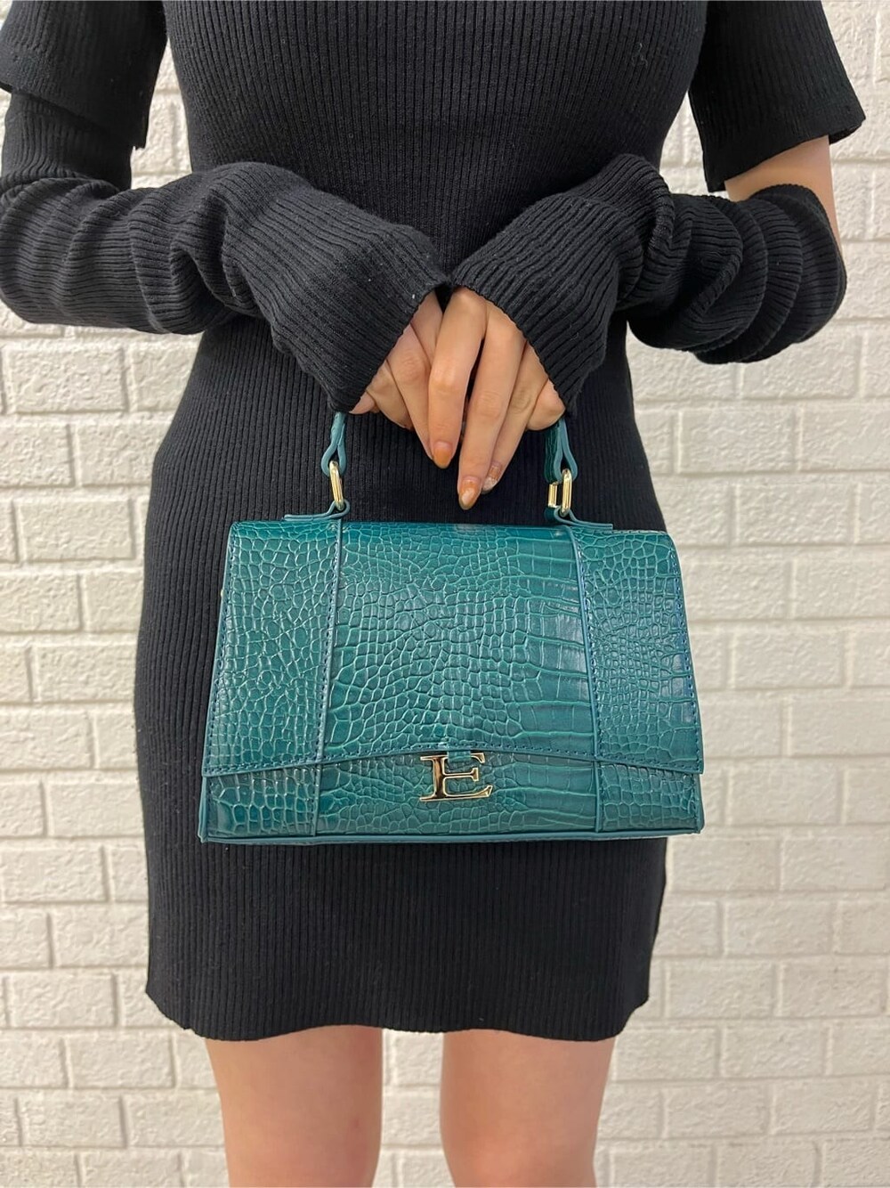 ブルー系のテーラードジャケット、ブラック系のワンピース、ブラック系のブーツを着用したレディースの秋コーディネートの6枚目の写真