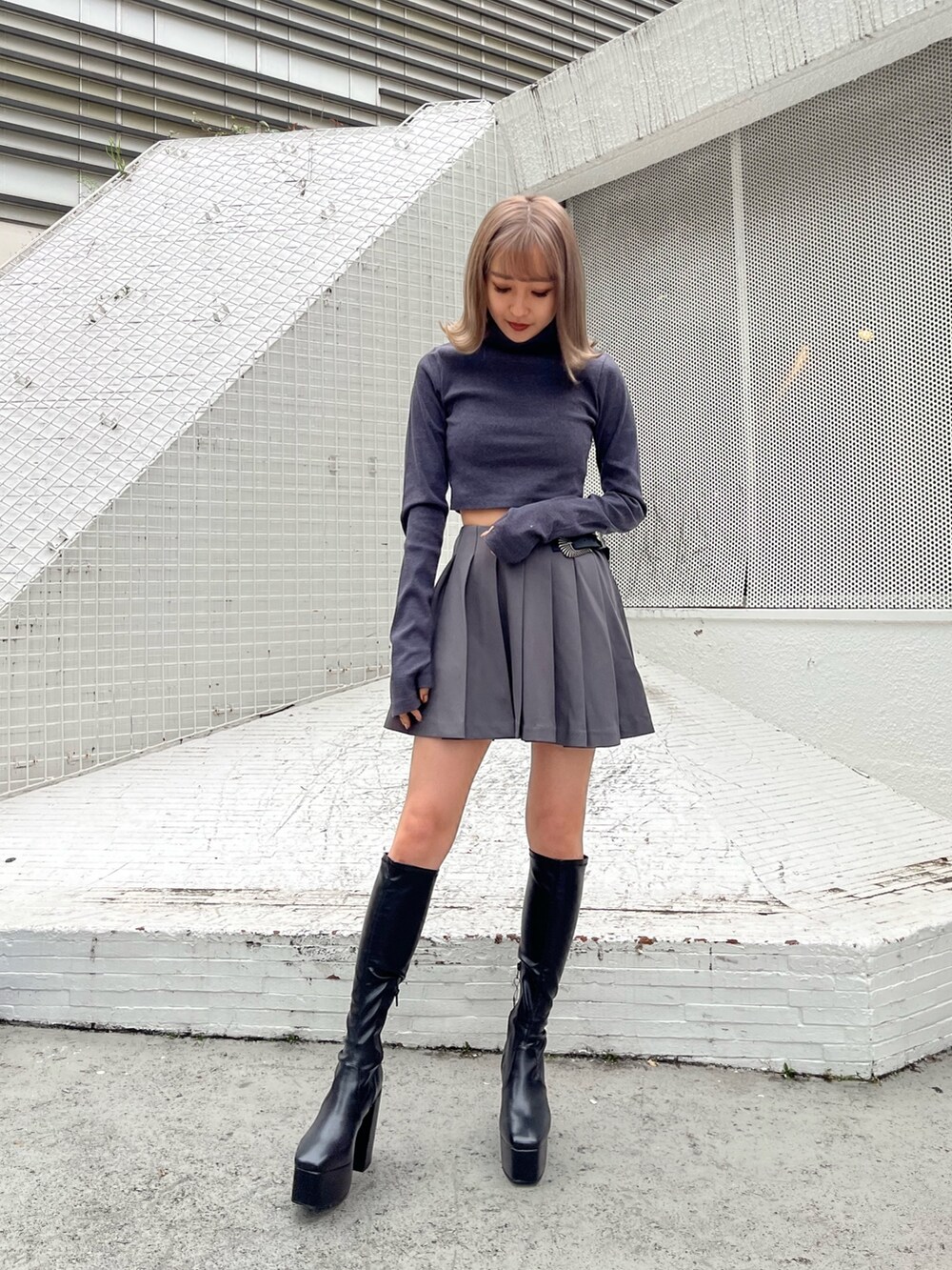 グレー系のスカート、グレー系のTシャツ/カットソー、ホワイト系のブーツを着用したレディースの秋コーディネートの5枚目の写真