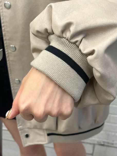 ブラック系のワンピース、ブラック系のブーツ、ベージュ系のブルゾンを着用したレディースの秋コーディネートの4枚目の写真