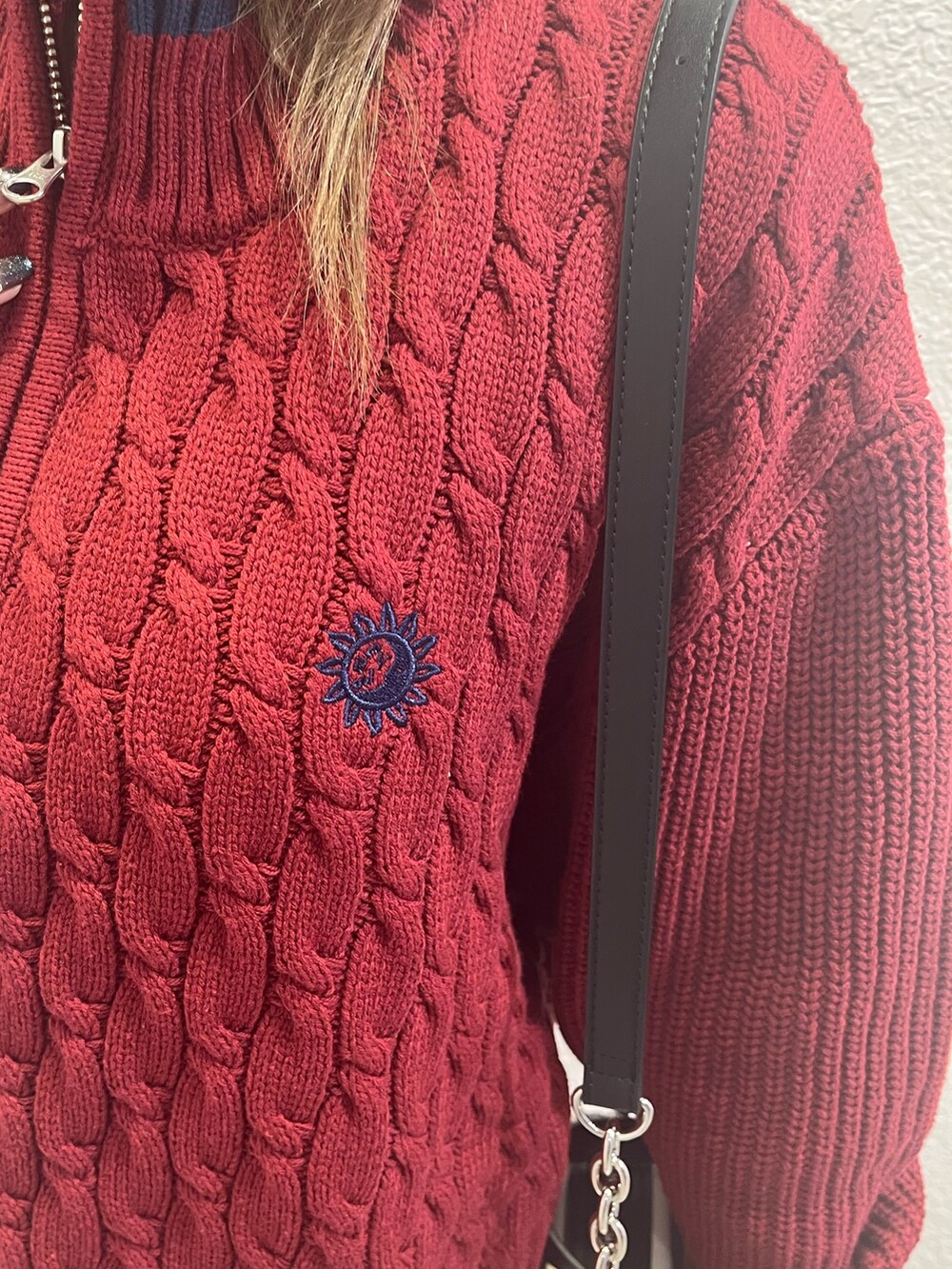 レッド系のニット/セーター、シルバー系のブーツ、ホワイト系のショルダーバッグを着用したレディースの夏コーディネートの6枚目の写真