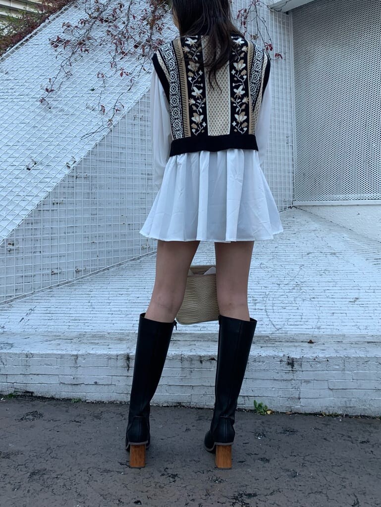 ホワイト系のショルダーバッグ、ブラック系のブーツ、ブラック系のシャツ/ブラウスを着用したレディースの冬コーディネートの2枚目の写真