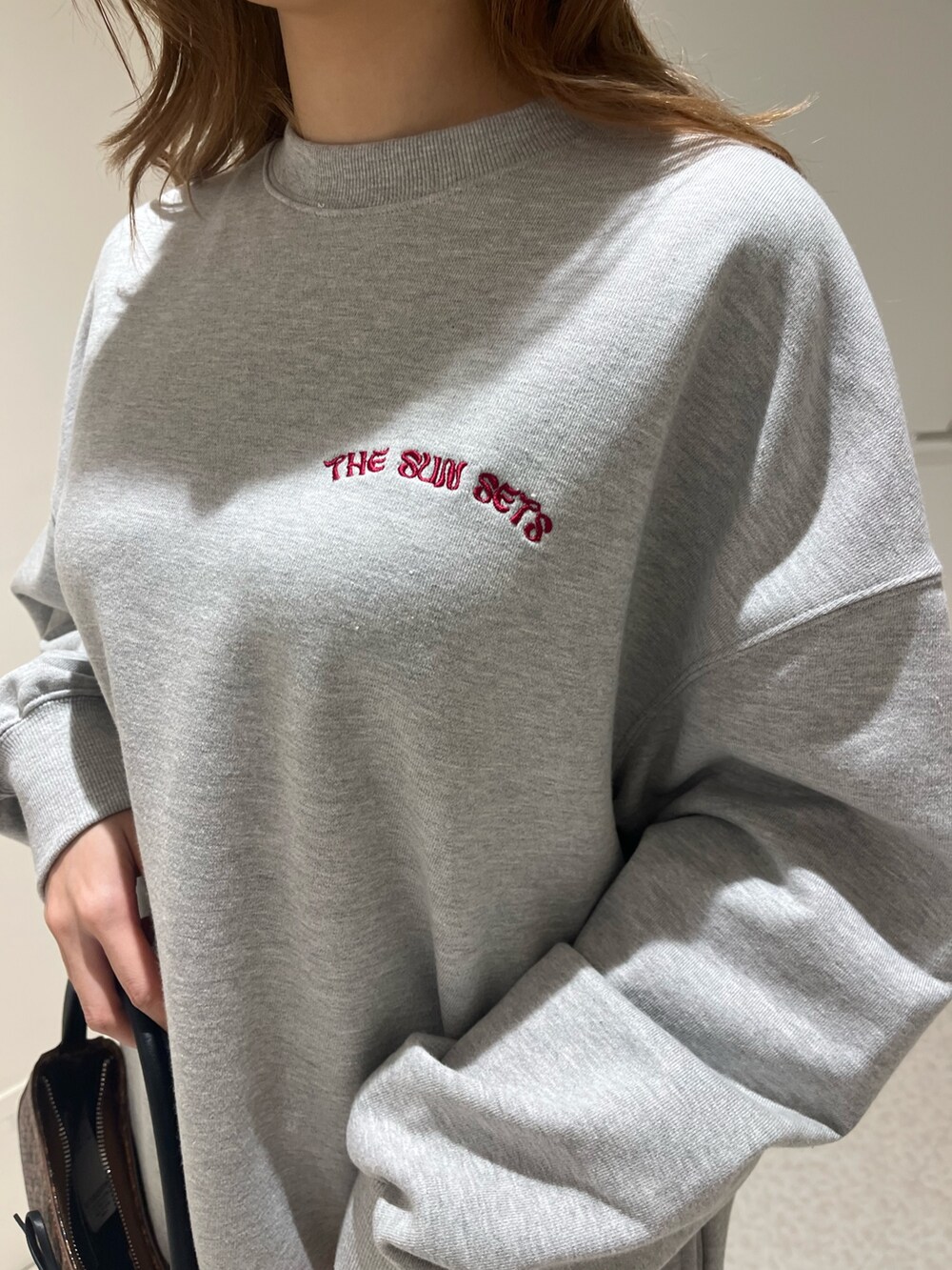 ブラック系のブーツ、ブラウン系のハンドバッグ、グレー系のスウェットを着用したレディースの春コーディネートの5枚目の写真