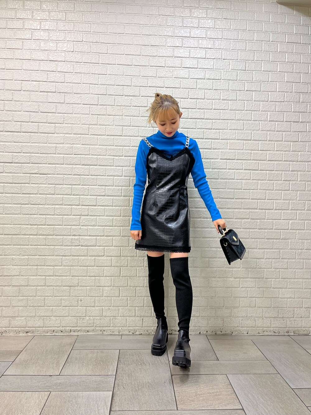 ブラック系のブーツ、ブラック系のワンピース、ブルー系のTシャツ/カットソーを着用したレディースの秋コーディネートの4枚目の写真