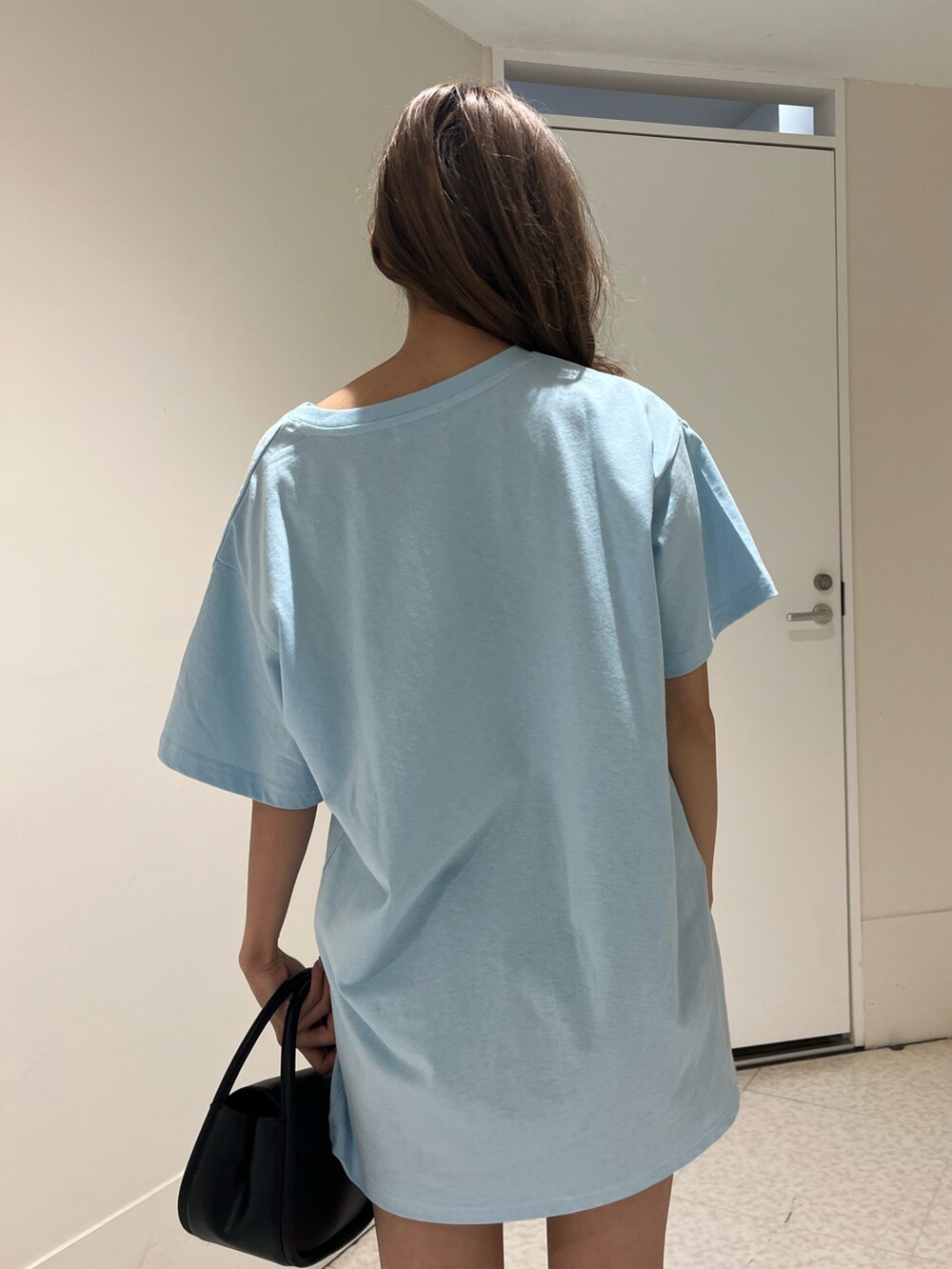 ブラック系のハンドバッグ、ブラック系のブーツ、ブルー系のTシャツ/カットソーを着用したレディースの春コーディネートの7枚目の写真