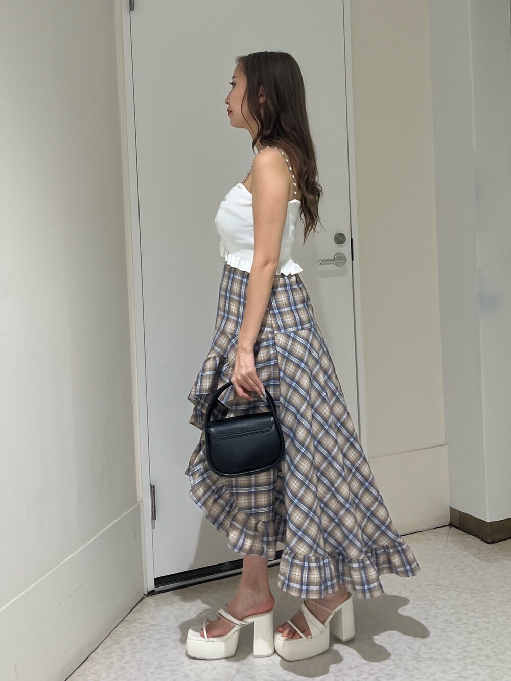 グレー系のスカート、レッド系のキャミソール、ブラック系のハンドバッグを着用したレディースの夏コーディネートの2枚目の写真