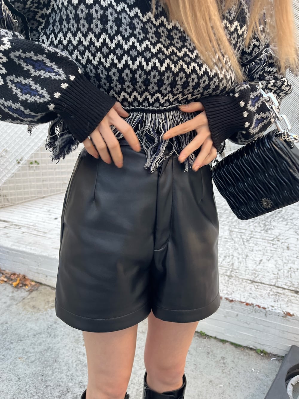 ブラック系のニット/セーター、ベージュ系のその他パンツ、ブラック系のブーツを着用したレディースの冬コーディネートの7枚目の写真