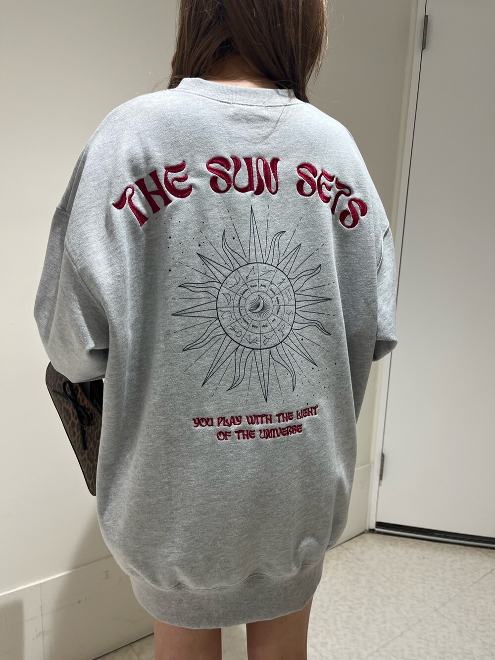 ブラック系のブーツ、ブラウン系のハンドバッグ、グレー系のスウェットを着用したレディースの春コーディネートの6枚目の写真