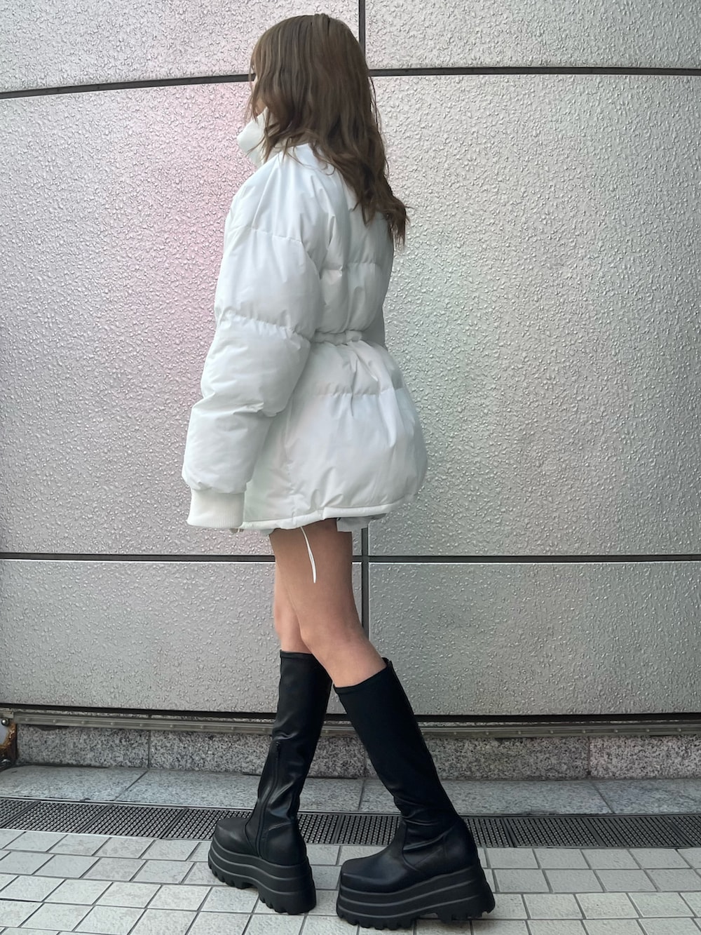 ブラック系のデニムスカート、ブラック系のTシャツ/カットソー、ブラック系のブーツを着用したレディースの冬コーディネートの3枚目の写真