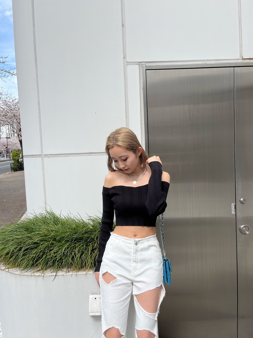 グリーン系のニット/セーター、ブラック系のデニムパンツ、ブラック系のショルダーバッグを着用したレディースの春コーディネートの10枚目の写真