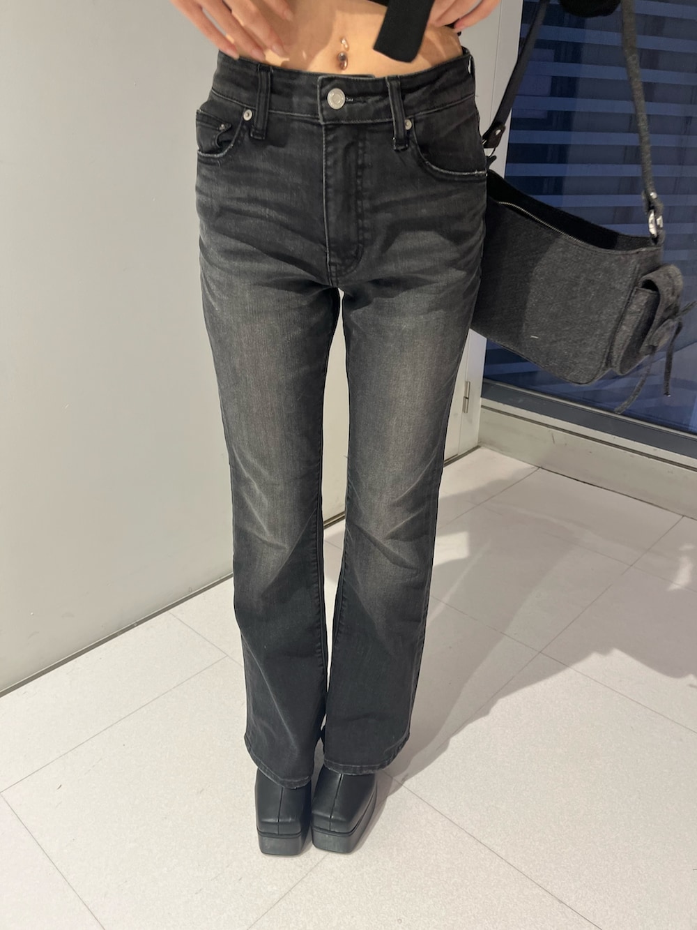 レッド系のニット/セーター、ブラック系のデニムパンツ、ブルー系のショルダーバッグを着用したレディースの秋コーディネートの5枚目の写真