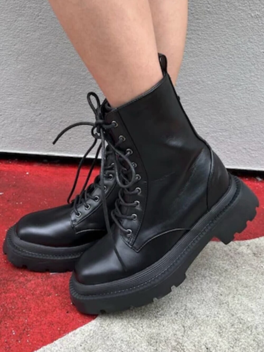 ブラック系のブーツ、ブラウン系のハンドバッグ、ブルー系のデニムパンツを着用したレディースの春コーディネートの7枚目の写真