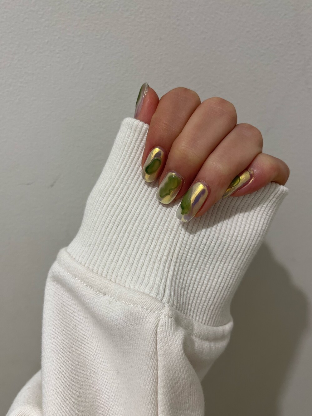 ホワイト系のパーカー、パープル系のスタジャン、ブラック系のブーツを着用したレディースの冬コーディネートの7枚目の写真