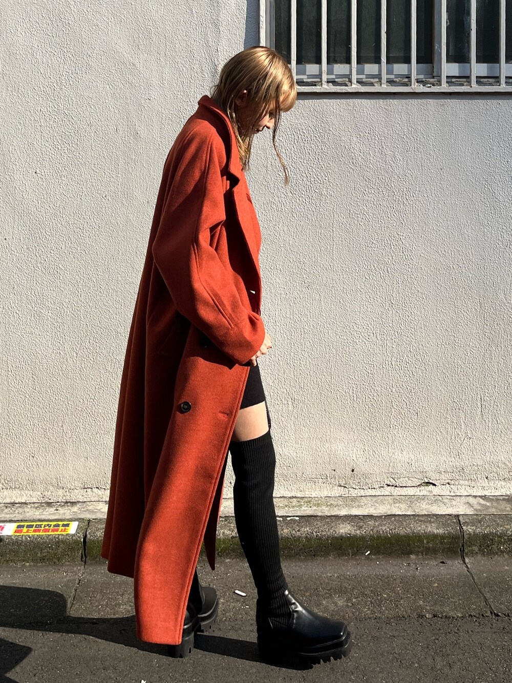 ブラック系のワンピース、オレンジ系のその他アウター、ブラック系のショルダーバッグを着用したレディースの冬コーディネートの3枚目の写真