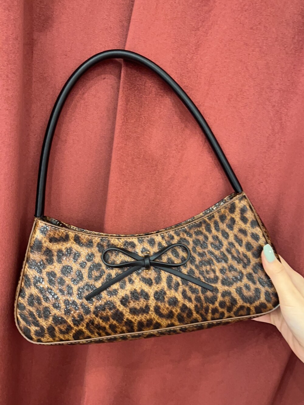 ブラウン系のハンドバッグ、ブラック系のブーツ、ブラック系のTシャツ/カットソーを着用したレディースの春コーディネートの8枚目の写真