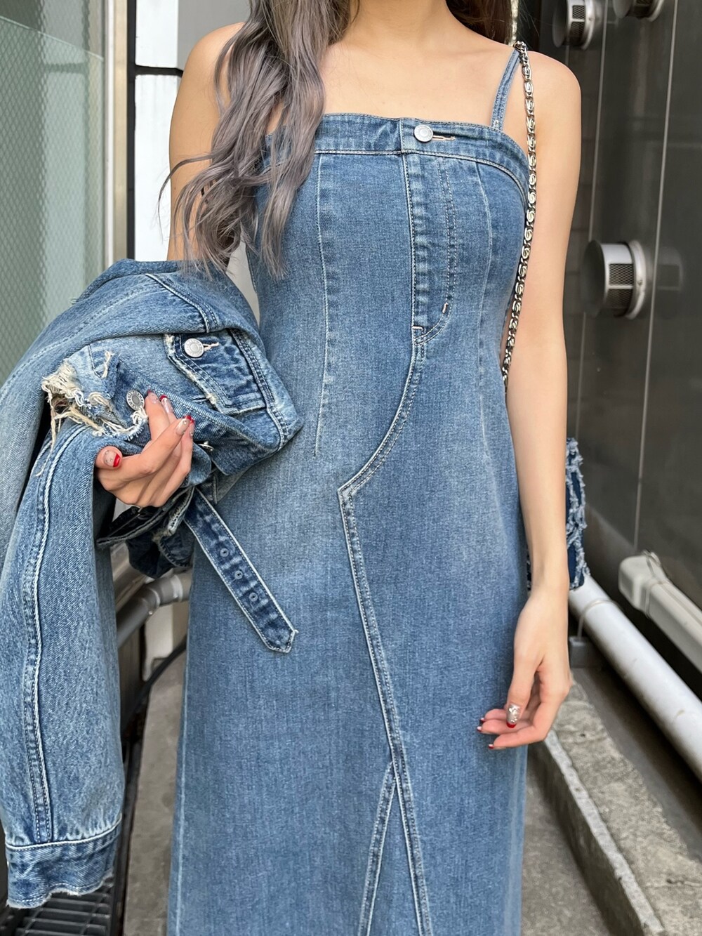 ブルー系のデニムジャケット、ブルー系のワンピース、ブルー系のショルダーバッグを着用したレディースの冬コーディネートの6枚目の写真