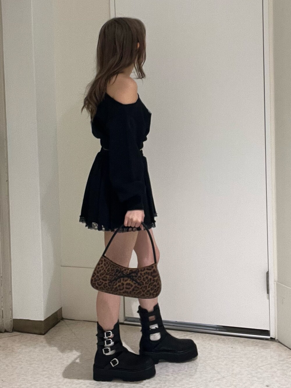 ブラック系のスウェット、ブラック系のスカート、ブラック系のブーツを着用したレディースの春コーディネートの2枚目の写真