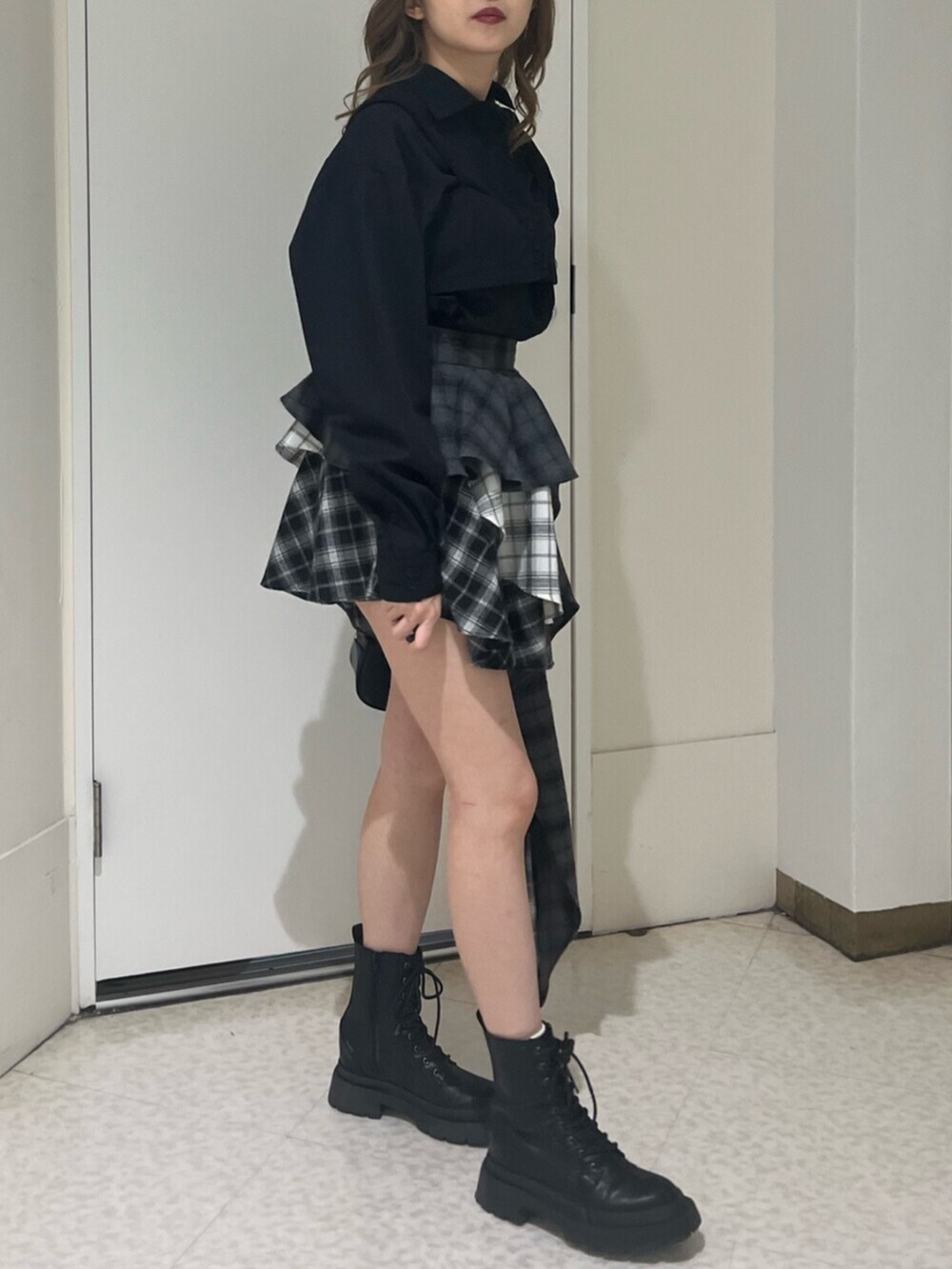 ブラック系のブーツ、ブラック系のボストンバッグ、ブラック系のスカートを着用したレディースの春コーディネートの4枚目の写真