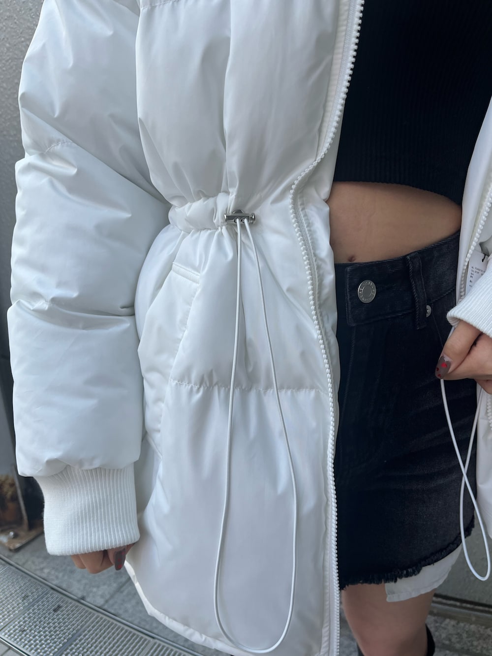 ブラック系のデニムスカート、ブラック系のTシャツ/カットソー、ブラック系のブーツを着用したレディースの冬コーディネートの6枚目の写真