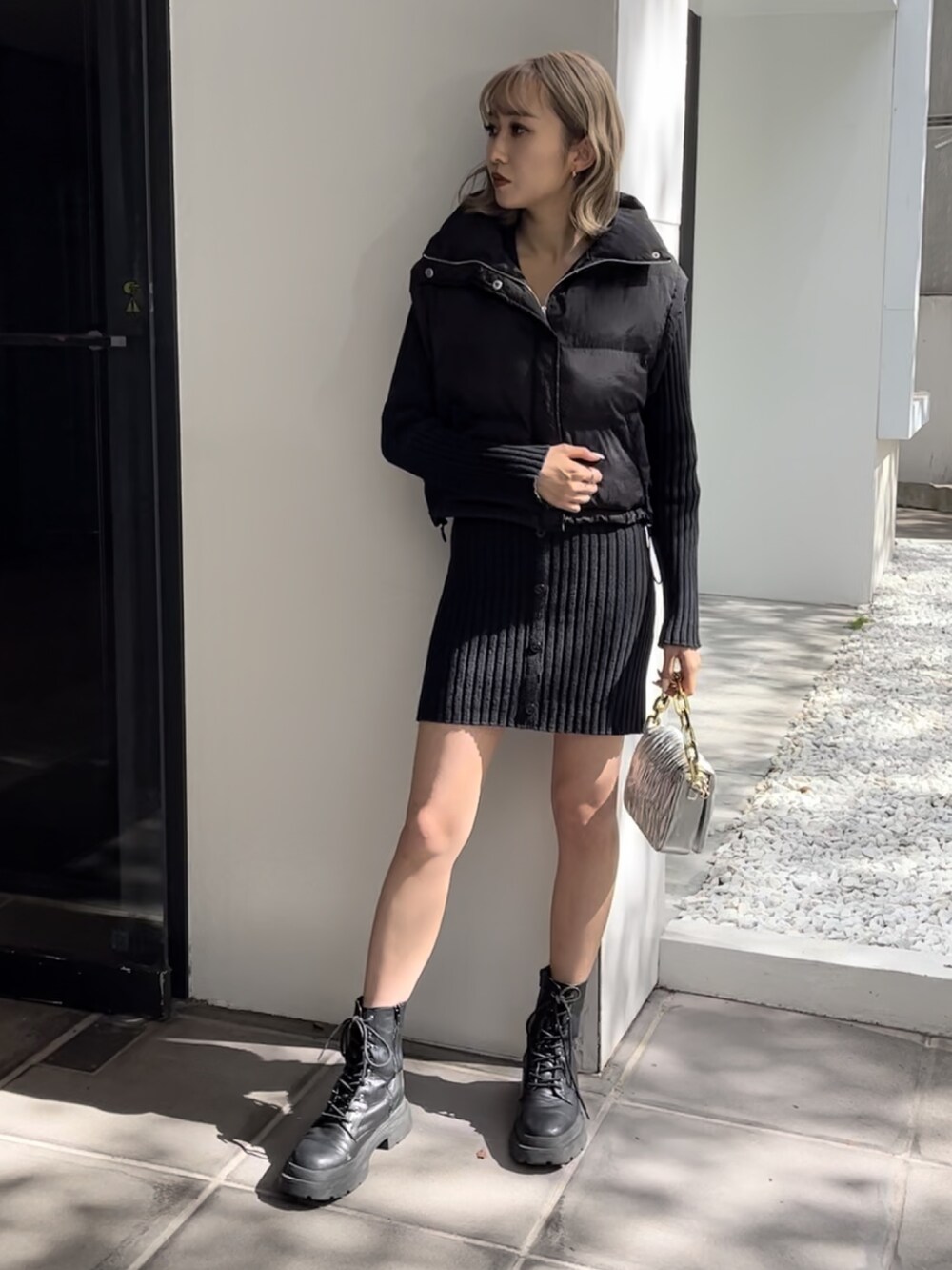 ブラック系のワンピース、シルバー系のショルダーバッグ、ホワイト系のブーツを着用したレディースの秋コーディネートの7枚目の写真