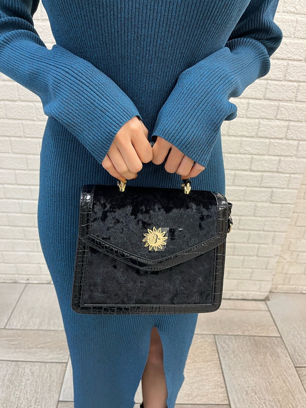 ブラック系のブルゾン、ブラック系のショルダーバッグ、ブルー系のワンピースを着用したレディースの冬コーディネートの7枚目の写真