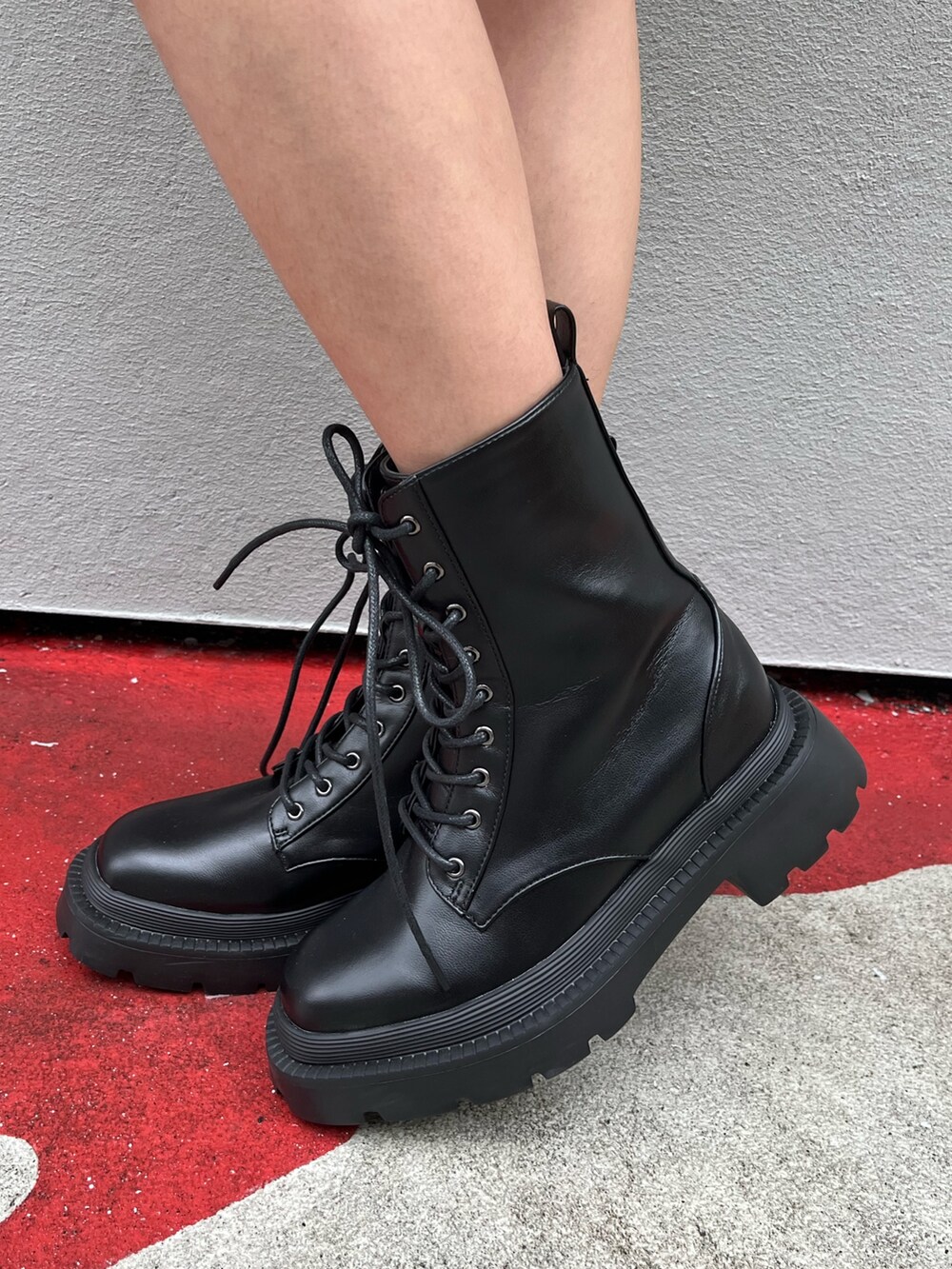 ブラック系のブーツ、ブルー系のデニムスカート、ブラック系のハンドバッグを着用したレディースの春コーディネートの8枚目の写真